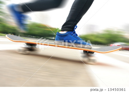 speeding skateboarding woman at city  13450361