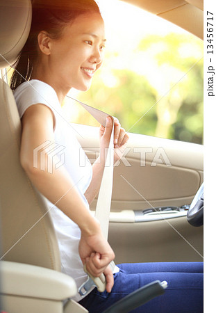 woman driver buckle up the seat belt before driving car  13456717