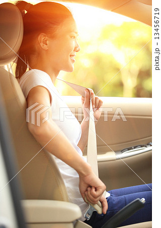woman driver buckle up the seat belt before driving car  13456719