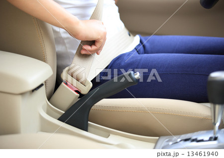 woman driver buckle up the seat belt before driving car  13461940
