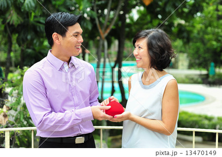 Asian man presented gift to his lady  in celebration of their love / anniversay / Valentine Day 13470149