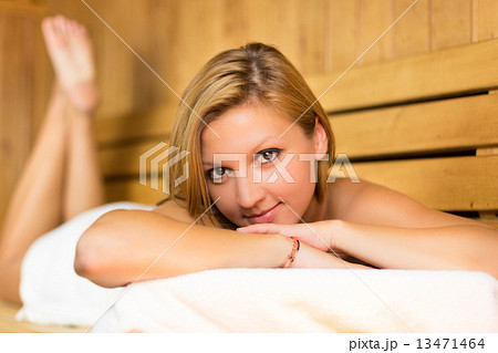 Lady relaxing in traditional wooden sauna. 13471464