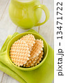 Waffles  in the green bowl with jug of milk 13471722