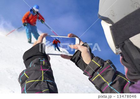 Photographed skiers with cell phone 13478046