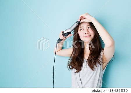 ヘアアイロンを使う女性 13485839
