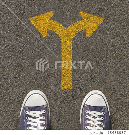 Pair of shoes standing on a road with traffic sign 13488087