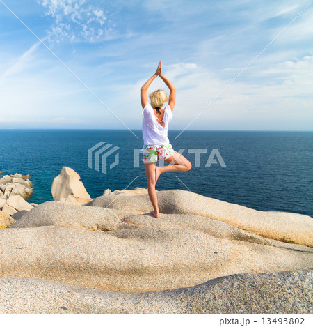Woman practicing yoga at the beach. 13493802