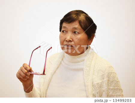 眼鏡を外す60代の女性 13499203