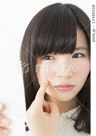 ニキビを気にする若い女性 ニキビを気にする若い女性 13499508