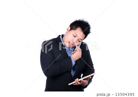 Asian business man on phone and taking notes Asian business man on phone and taking notes 13504395
