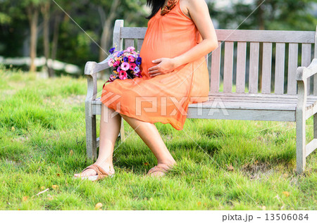 Pregnant woman sitting in the park outdoor. 13506084