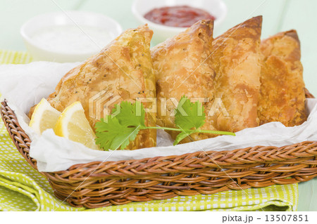 Samosas - Deep fried stuffed pasties with lemon wedges and dips  13507851
