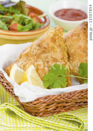 Samosas - Deep fried stuffed pasties with lemon wedges and dips  13507854