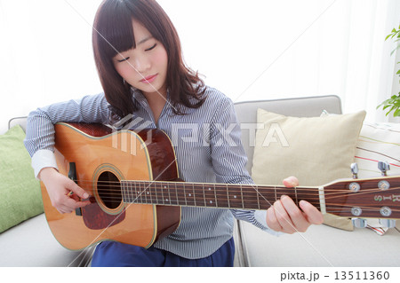 ギターを持ってる若い女性の写真素材