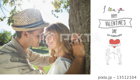 Composite image of cute smiling couple leaning against tree in t 13512104