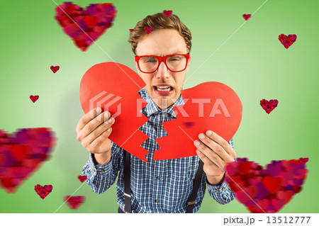 Composite image of geeky hipster holding a broken heart Composite image of geeky hipster holding a broken heart 13512777