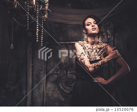 Tattooed beautiful woman in old spooky interior 13520076