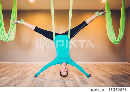 Young woman performing antigravity yoga exercise 13520078