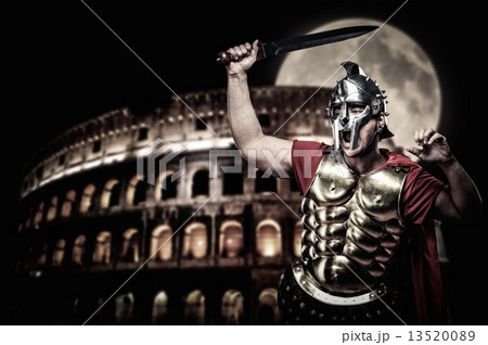 Roman legionary soldier in front of coliseum at night time Roman legionary soldier in front of coliseum at night time 13520089