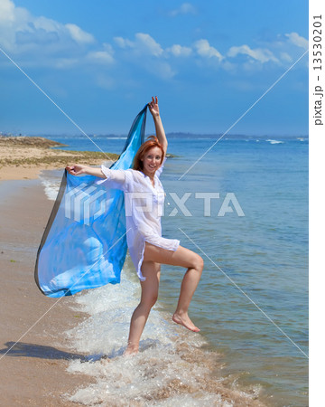 attractive woman with a beach scarf in hands 13530201