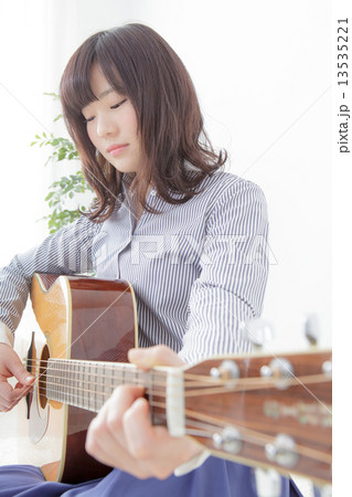 ギターを持ってる若い女性の写真素材