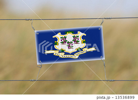 Border fence - Old plastic sign with a flag Border fence - Old plastic sign with a flag 13536899