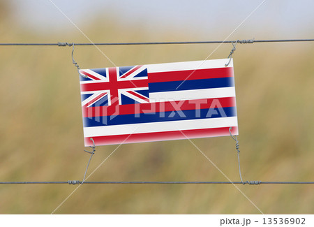 Border fence - Old plastic sign with a flag Border fence - Old plastic sign with a flag 13536902