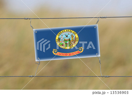 Border fence - Old plastic sign with a flag 13536903