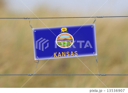 Border fence - Old plastic sign with a flag 13536907