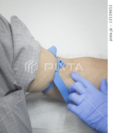 Nurse and male patient blood sample donation 13539652