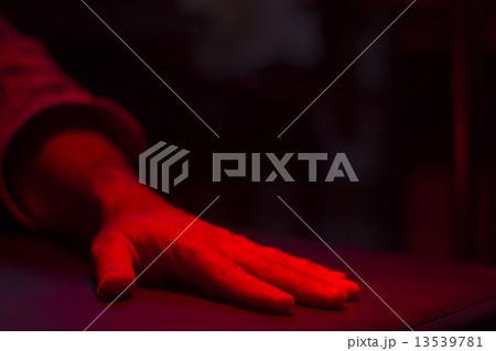 Hand of patient under red rehabilitation clinic heat lamp 13539781
