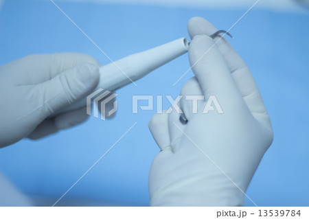 Dental nurse attaching ultrasound teeth cleaning attachment 13539784