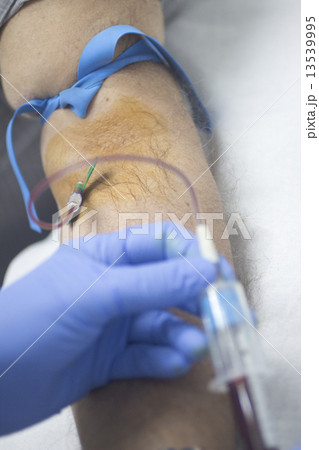 Nurse and male patient blood sample donation 13539995