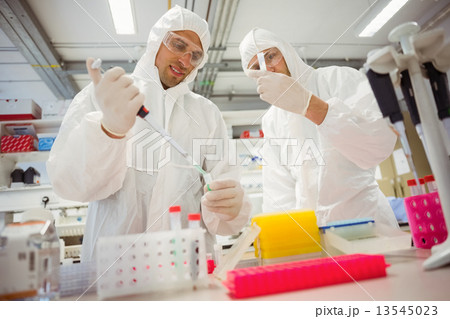 Science students working in protective suits 13545023