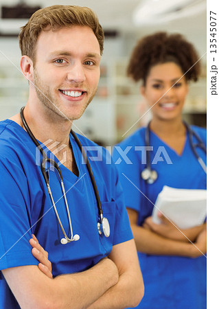 Young medical students smiling at the camera Young medical students smiling at the camera 13545077