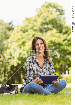 Smiling student sitting and using tablet pc 13545546