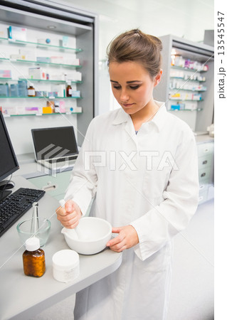 Junior pharmacist mixing a medicine 13545547