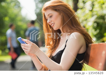 Pretty student sending a text outside 13545620