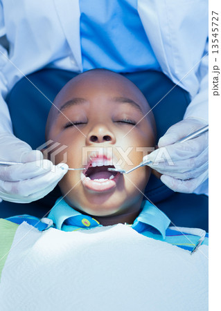 Close up of boy having his teeth examined 13545727