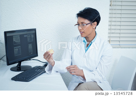 Dentist holding mouth model besides computer 13545728