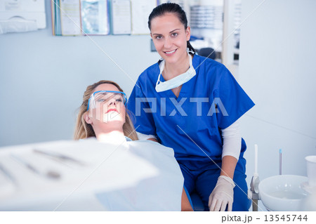 Dentist and her assistant smiling at camera 13545744