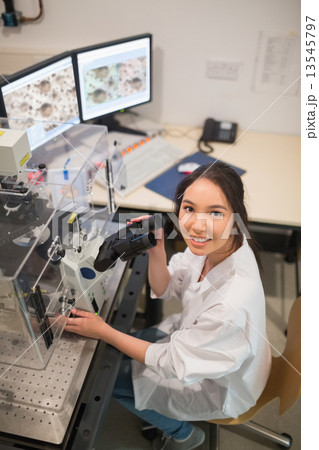 Biochemistry student using large microscope and computer 13545797