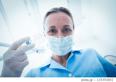 Female dentist in surgical mask holding injection 13545801