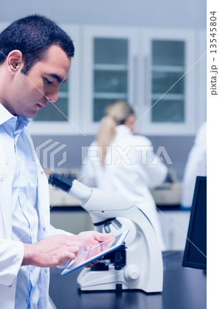 Science student working with microscope in the lab 13545804