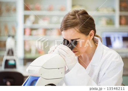 Young scientist working with microscope 13546211