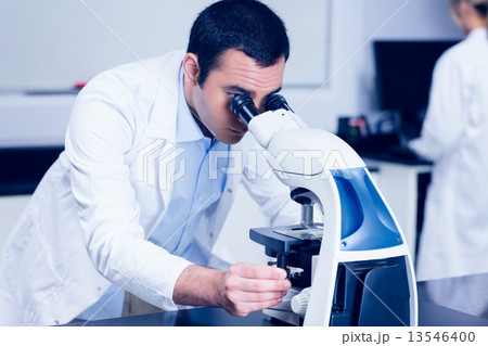 Science student looking through microscope Science student looking through microscope 13546400