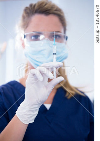 Dentist in mask and glove holding an injection Dentist in mask and glove holding an injection 13546670