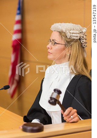 Stern judge sitting and listening 13547139