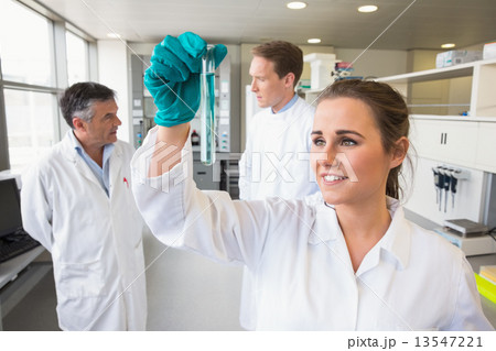 Young scientist holding up test tube 13547221