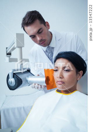 Serious young woman undergoing dental checkup 13547222